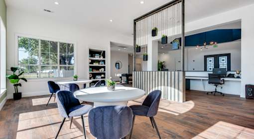 A modern dining room with a white table and blue chairs.