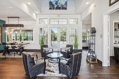 A modern living room with a glass door entrance and a dining area.