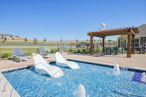 A pool with a waterfall and a pergola.