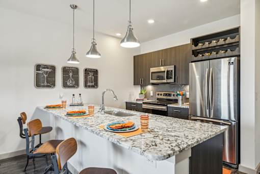 A kitchen with a marble countertop and a refrigerator.