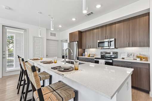 A modern kitchen with a white countertop and brown cabinets.