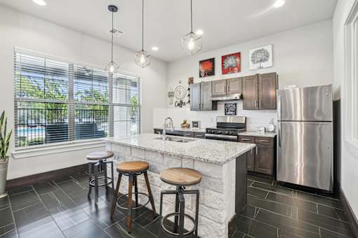 A kitchen with a white countertop and a stainless steel refrigerator.