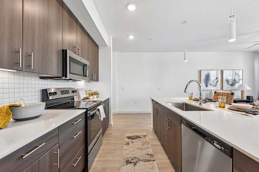 A modern kitchen with dark wood cabinets and stainless steel appliances.
