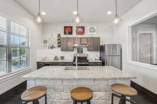 A kitchen with a marble countertop and wooden stools.