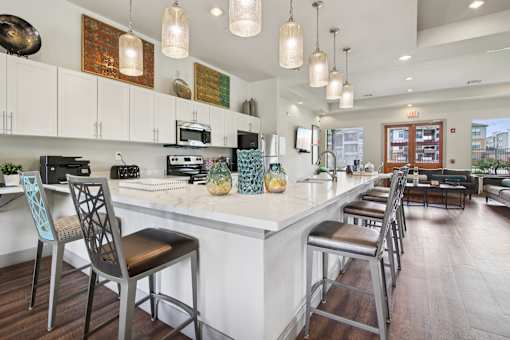 A kitchen with a white counter top and bar stools.