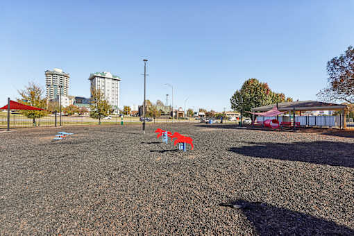 A playground with a red and blue slide and a red canopy structure.