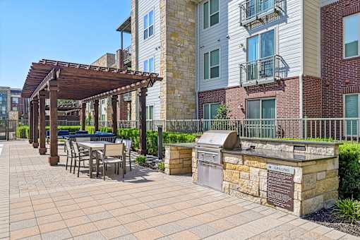 A patio with a table and chairs under a pergola.