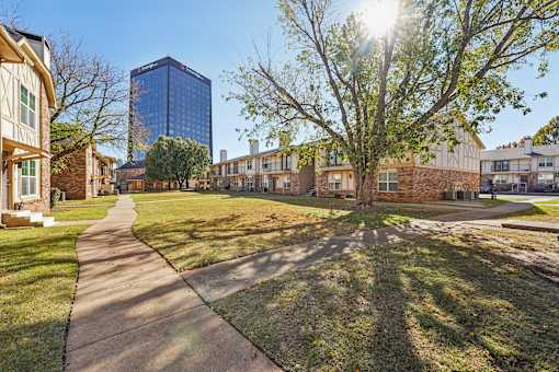 A sunny day in a residential area with a pathway and houses.