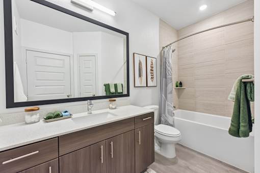 A bathroom with a white countertop and brown cabinets.
