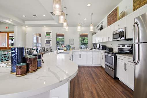 A modern kitchen with white cabinets and a wooden floor.