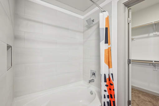 A white bathroom with a white tub and a white shower.