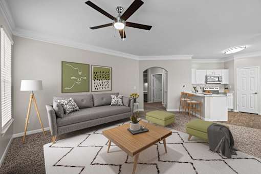 A living room with a grey couch, a coffee table, and a ceiling fan.
