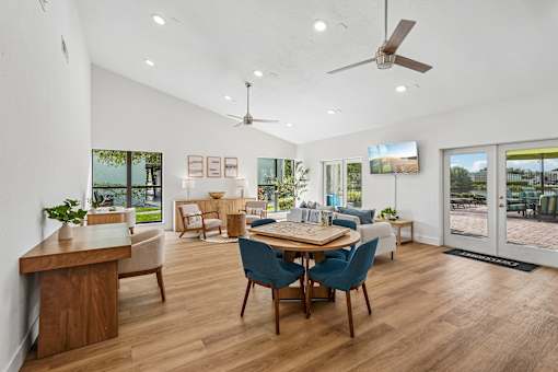 A modern living room with a wooden table and blue chairs.