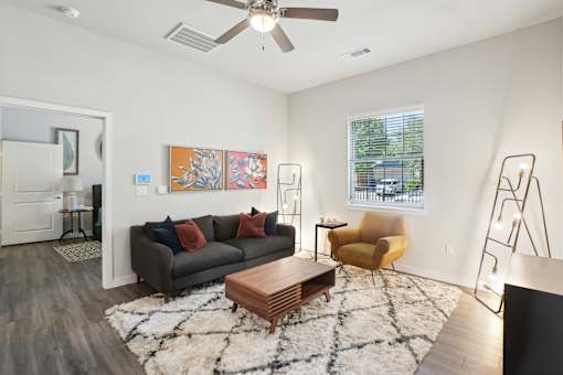 A living room with a brown couch, a yellow chair, and a wooden coffee table.