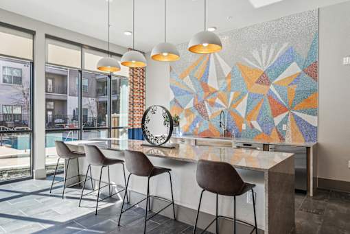 A modern kitchen with a large island and chairs.