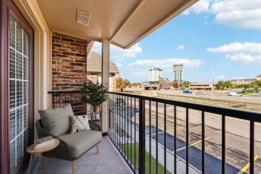 A balcony with a chair and a table.