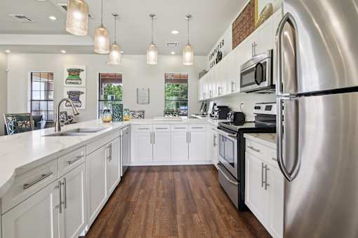 A modern kitchen with white cabinets and stainless steel appliances.