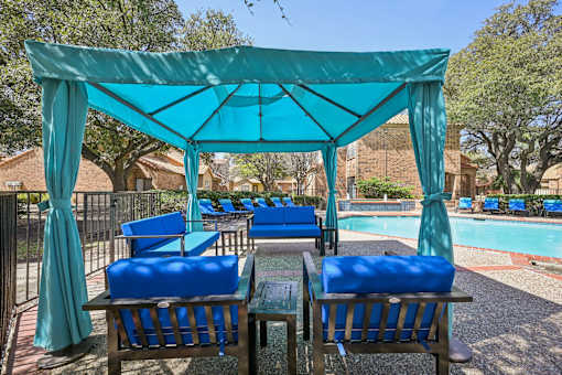 A poolside area with blue chairs and a canopy.