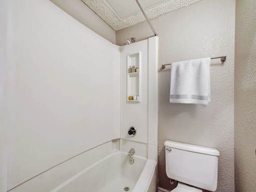 A white bathroom with a towel rack and a toilet.