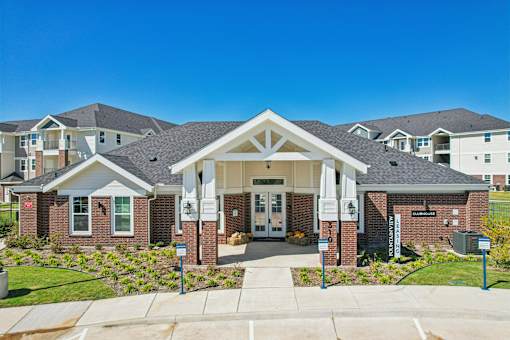 A large building with a white entrance and a sign that says "Welcome" in front of it.