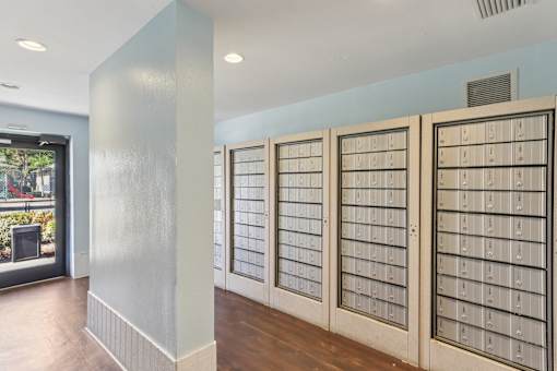 A room with a long row of mailboxes on the wall.