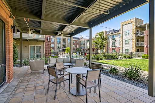 A patio with a table and chairs is set up outside a building.