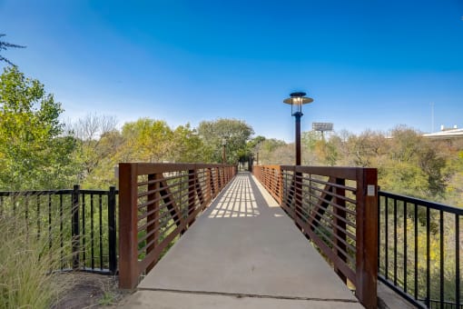 a bridge over a river with trees and a blue sky