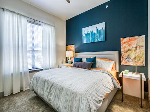 A bedroom with a bed, nightstand, and two lamps.