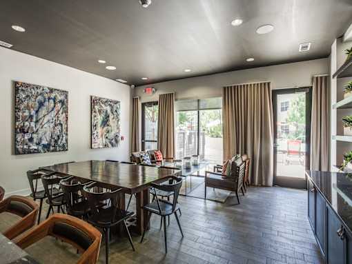 A dining room with a large table and chairs.
