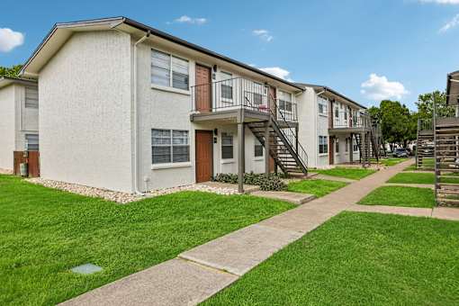 A row of houses with green lawns in front.