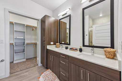 A bathroom with a white counter top and brown cabinets.