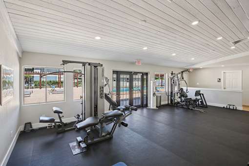 A gym with a view of the pool outside.