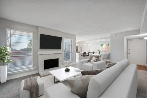 a living room with white couches and chairs and a fireplace