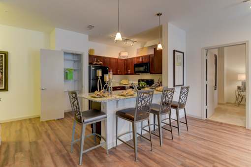 A kitchen with a table and chairs.