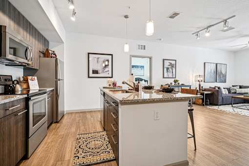 A kitchen with a white island and wooden floors.