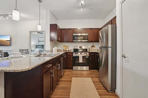 A kitchen with a refrigerator, stove, and microwave.