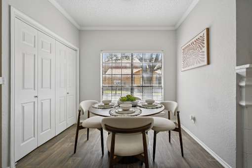 A dining room with a table set for four.
