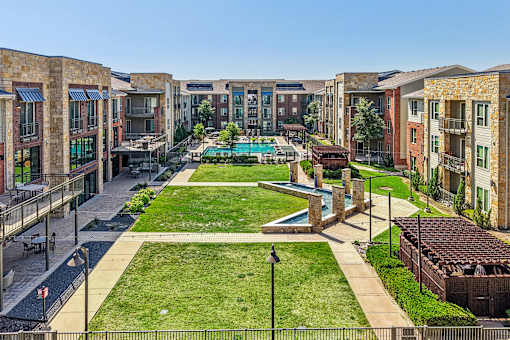 A view of a courtyard with a pool and a fence.