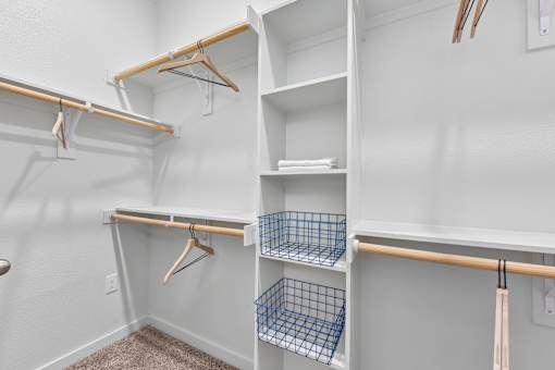 A white closet with shelves and hangers.