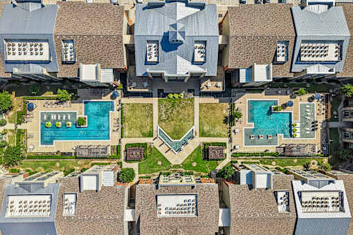 A bird's eye view of a residential area with houses and swimming pools.