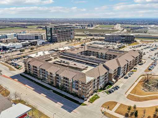 A large building complex with a parking lot in front.