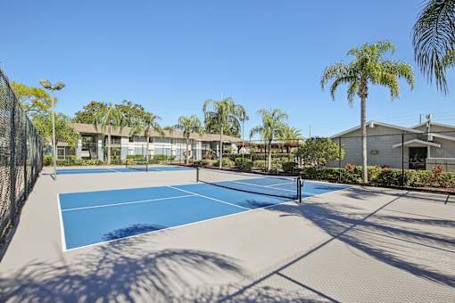 A tennis court with a net and a building in the background.