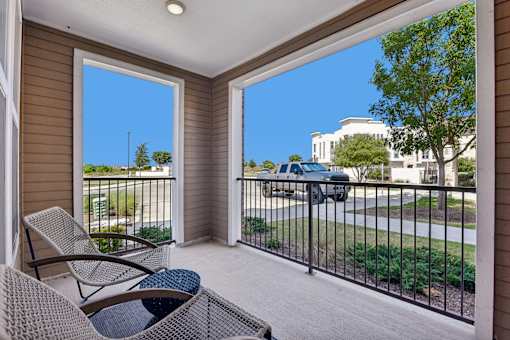 A balcony with a chair and a table.