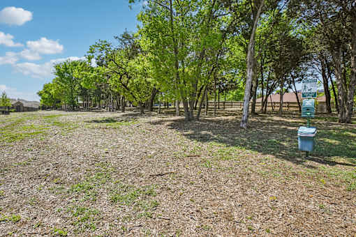 A field with trees and a blue container.
