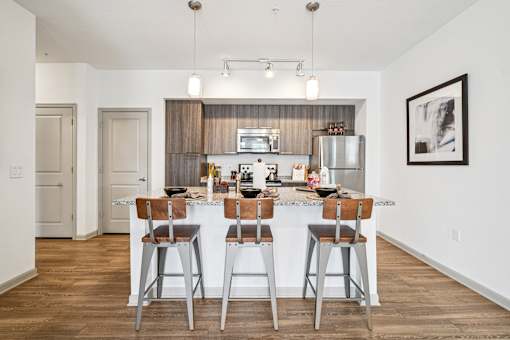 A kitchen with a bar area and a fridge.