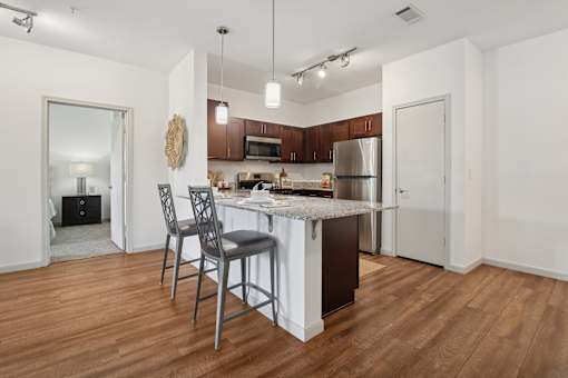 A kitchen with a white island and a single chair.