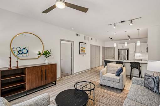 A living room with a grey couch, a black coffee table, and a wooden cabinet.