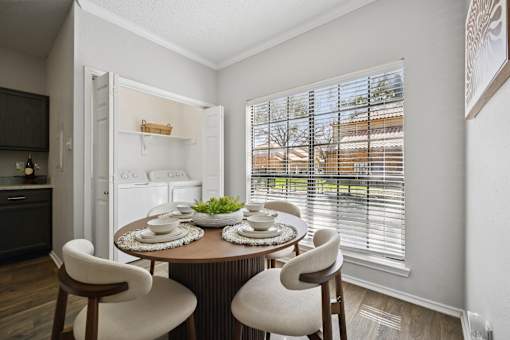 A dining room with a round table and chairs.