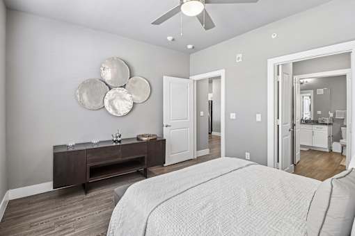 A bedroom with a large bed and a wooden dresser.