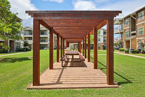 A wooden pergola with a bench underneath it.
